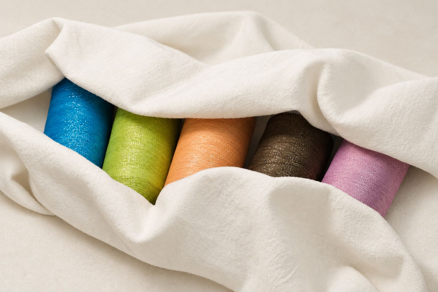 Colourful embroidery threads arranged in soft fabric